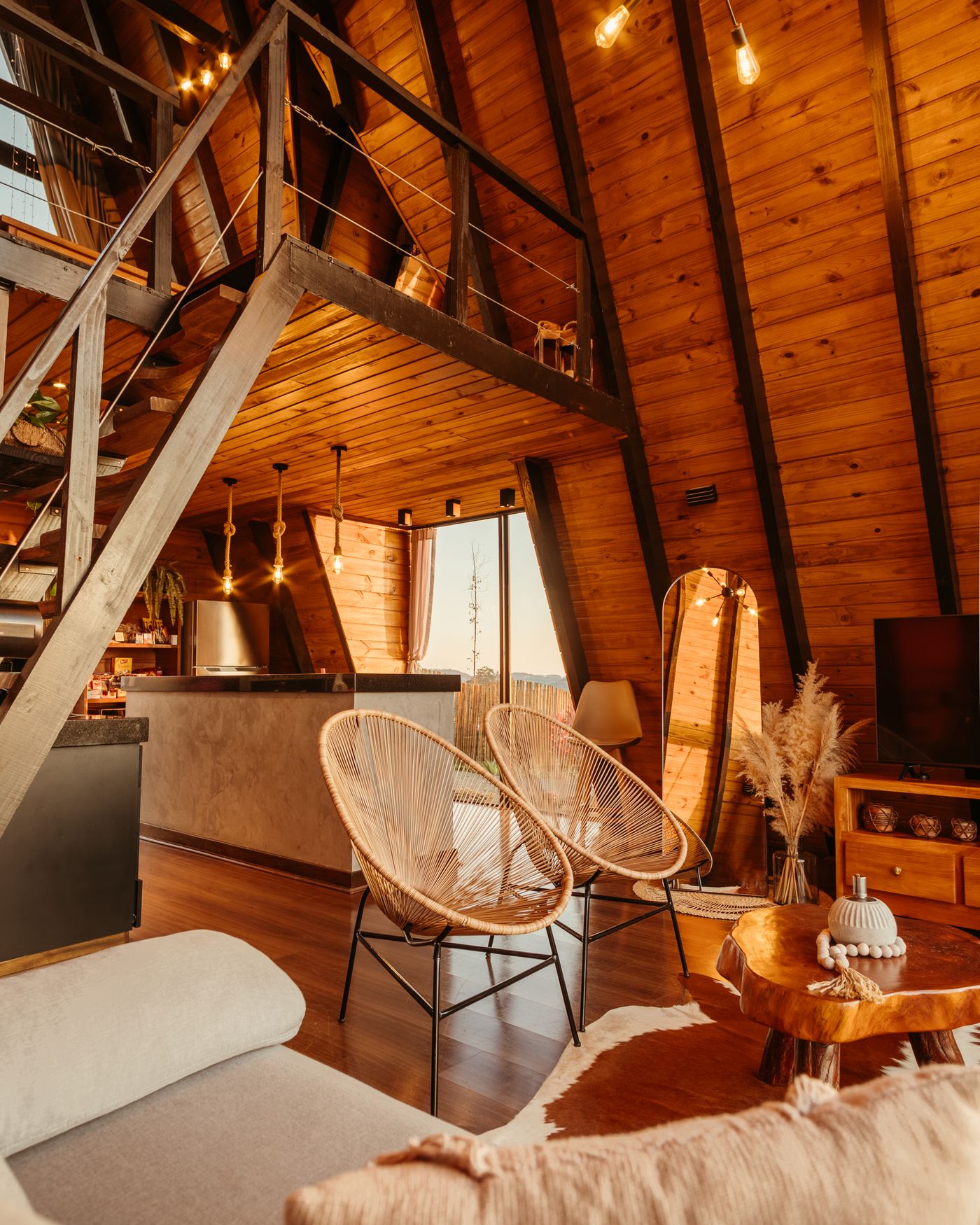 Warm A-frame interior with woven chairs